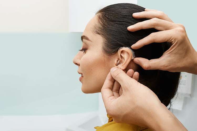 installation-hearing-aid-on-womans-ear-at-hearing-clinic-close-up-side-view-deafness